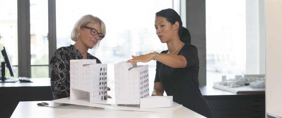 Kaksi naista suunnittelee talojen rakentamista