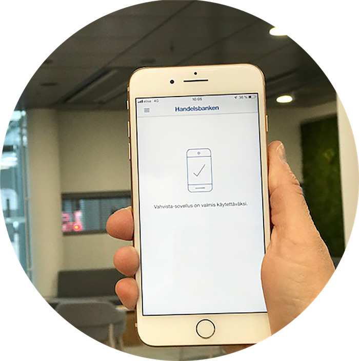 Puhelin kädessä ja Vahvista-palvelun ikkuna auki.