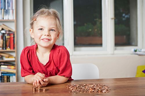 En liten flicka sorterar mynt