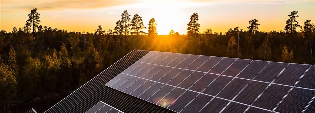 Solceller på taket i solnedgången.