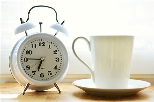 En veckarklocka med en kaffekopp
